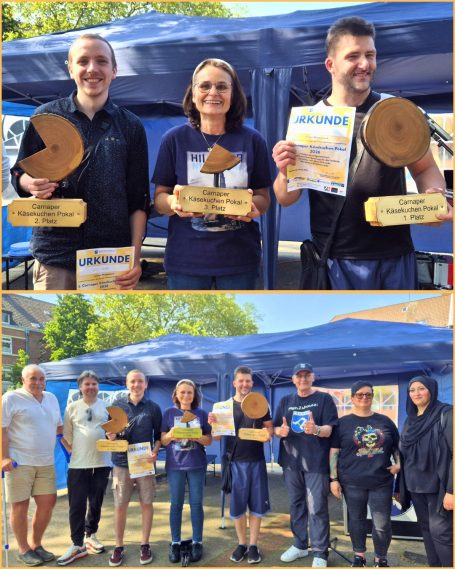 Drei Gewinner halten Trophäen und Urkunden vor einem Festzelt, umgeben von anderen Teilnehmern.