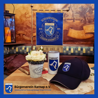 Dekorative Tischansicht mit Blume, Mütze und Banner des Bürgervereins Karnap e.V.
