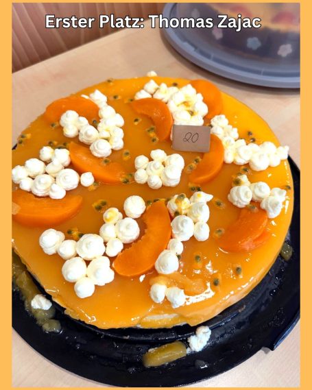 Eine orangefarbene Torte mit Mandarinenstücken und einer dekorativen Schicht Sahne.